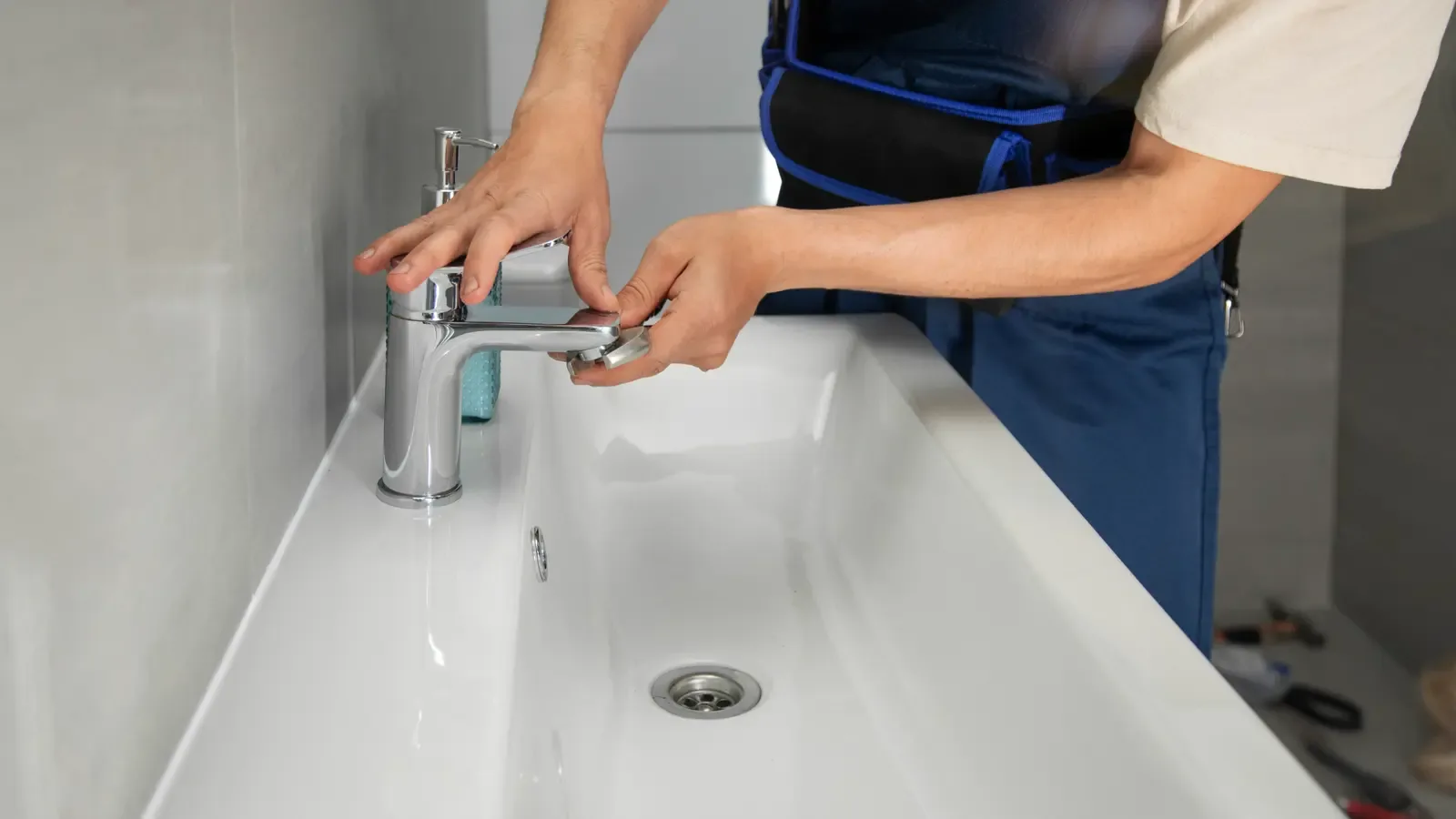 A plumber fixing a bathroom sink faucet