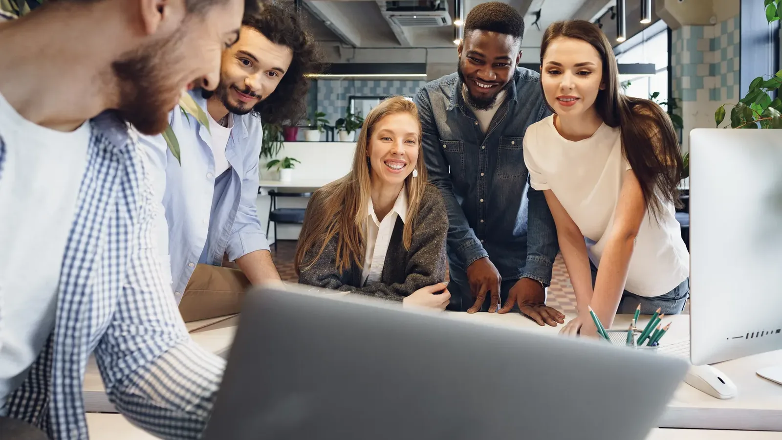 A marketing team gathered around a laptop planning an SEO campaign