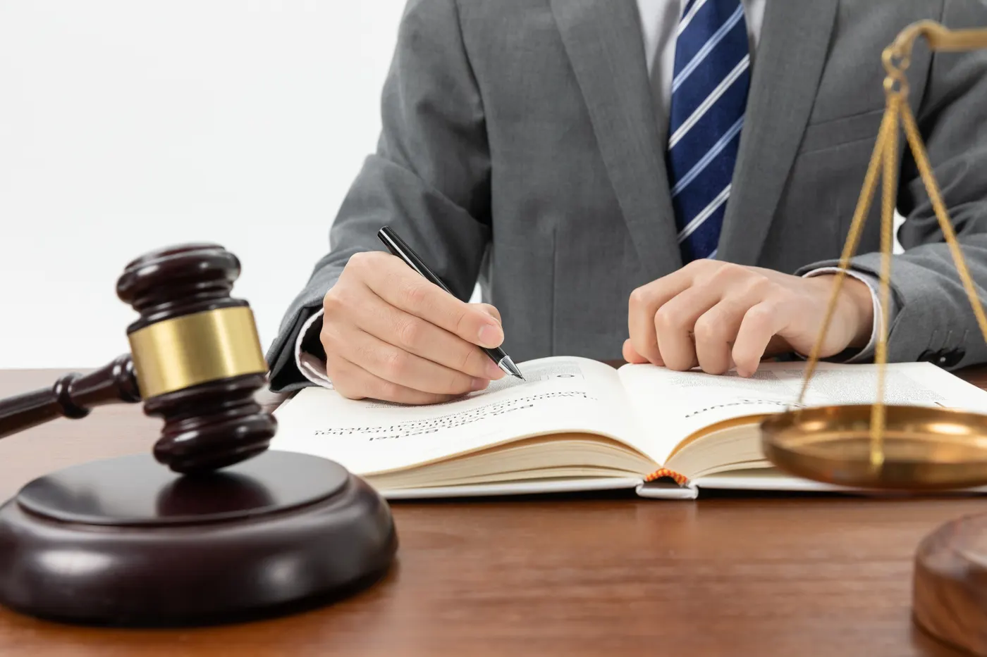 Lawyer taking notes beside a gavel and scales